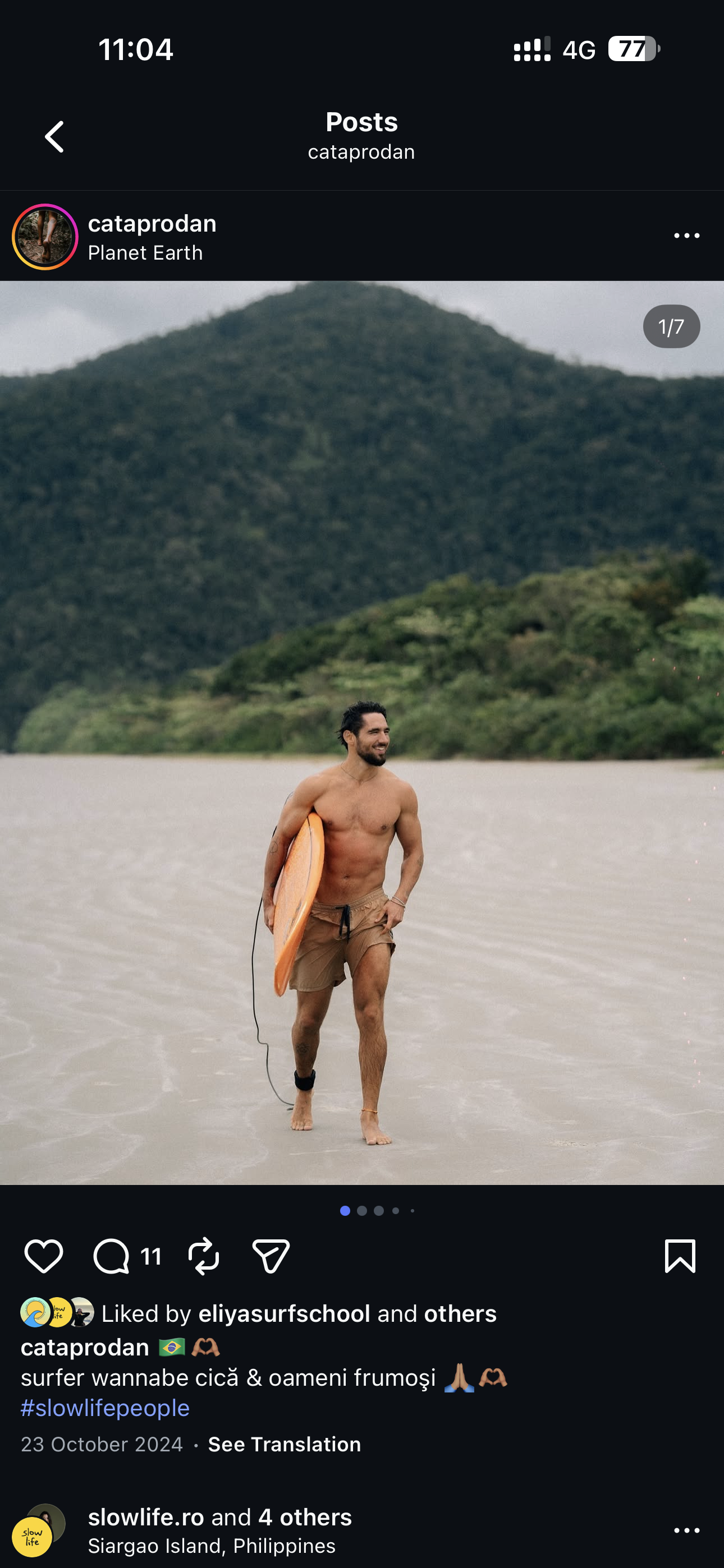 Earthlinks guest walking on a sandy beach holding a surfboard